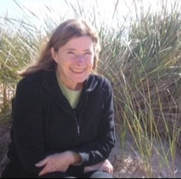 Smiling photo of Nancy Schemanski sitting in beach grasses